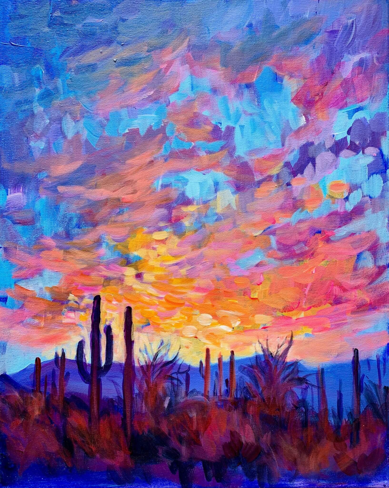 Colorful desert sunset painting with vivid pink, orange, yellow, and blue clouds filling the sky above dark silhouettes of cacti and desert plants.